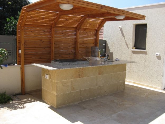 פינת ברבקיו מחופה כורכר עם משטח גרניט
